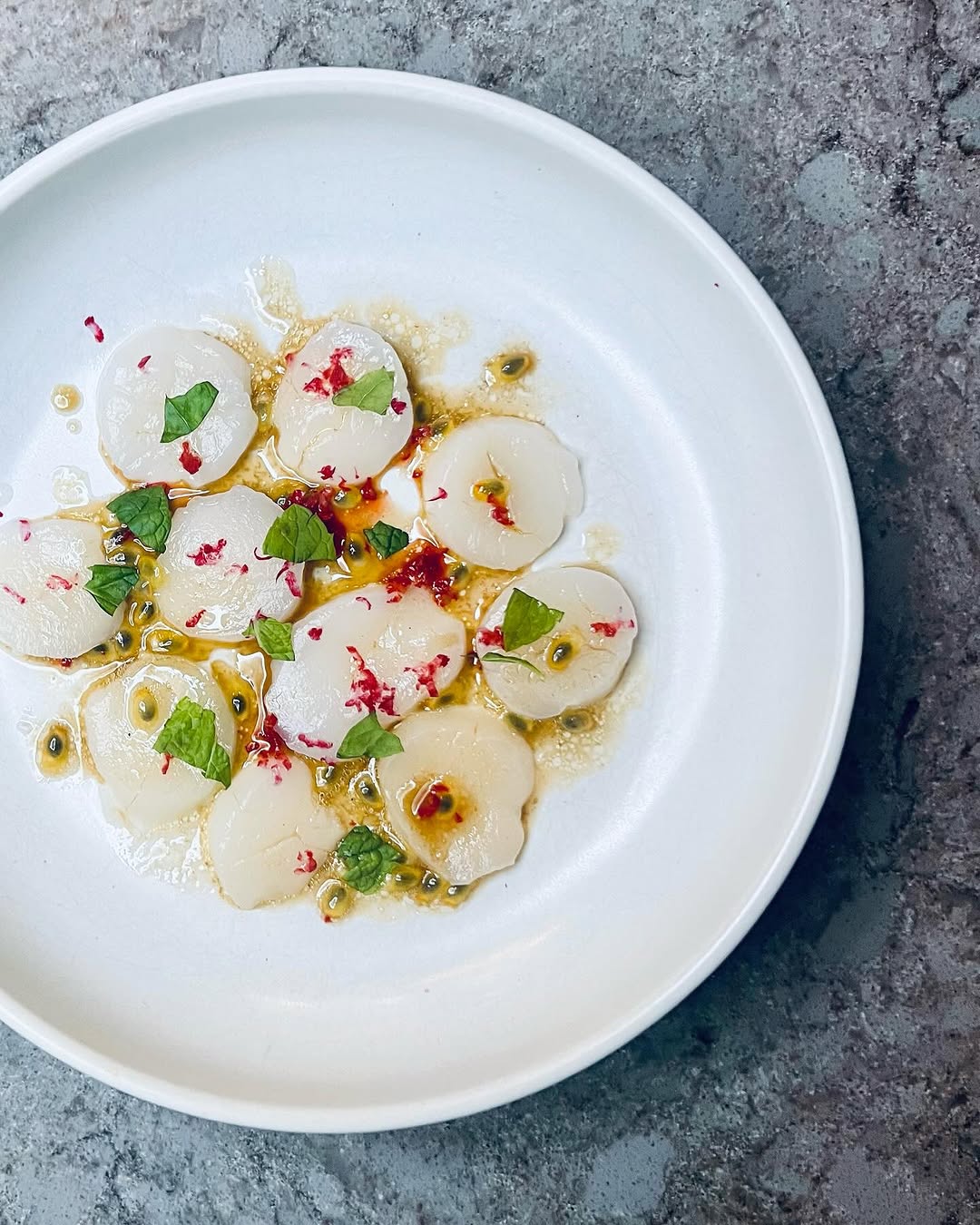 Crudo på pilgrimsmusslor, passionsfrukt och yuzu